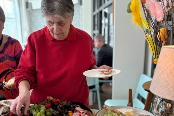 Påskfirande hemtjänstkund hämtar dessert på buffén.
