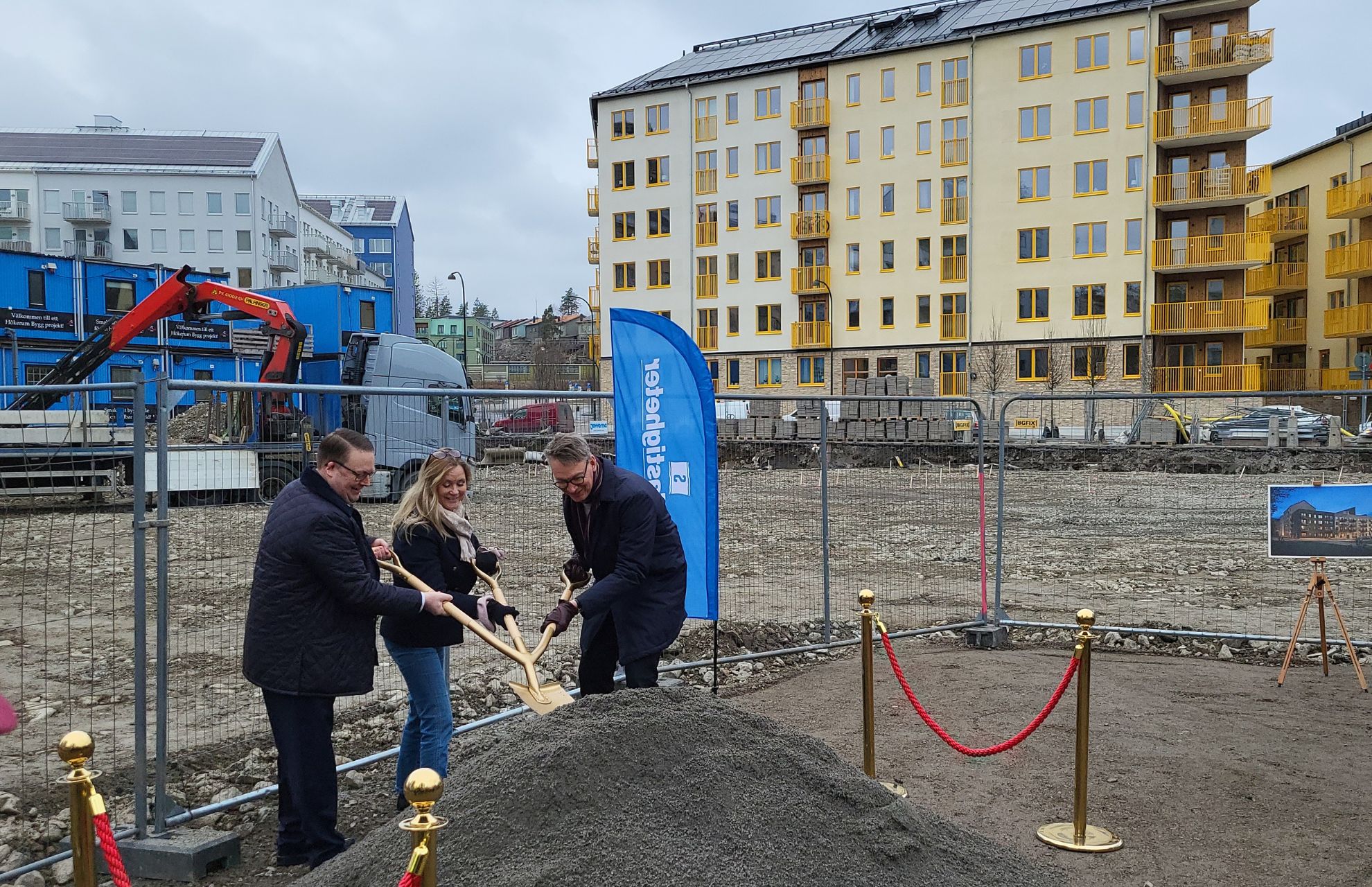 Tre personer som representerar de samarbetspartner som är involverade, tar ett symboliskt spadtag med spade med tre skaft