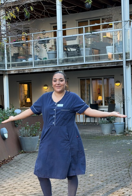 Undersk&ouml;terskan Solange st&aring;r stolt framf&ouml;r Attendo V&auml;stra Varvsgatan d&auml;r hon jobbar, str&auml;cker ut h&auml;nderna