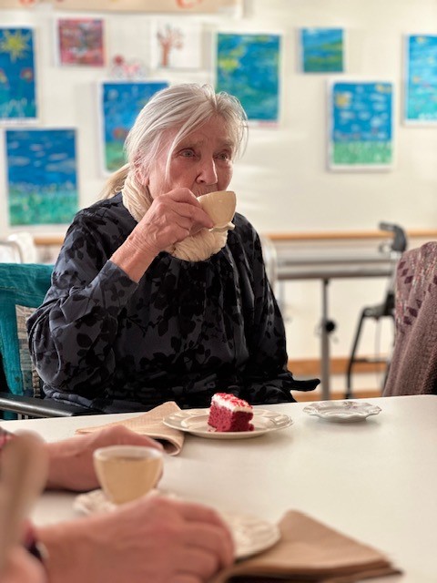 Kvinna på äldreboende dricker te ur fin tekopp