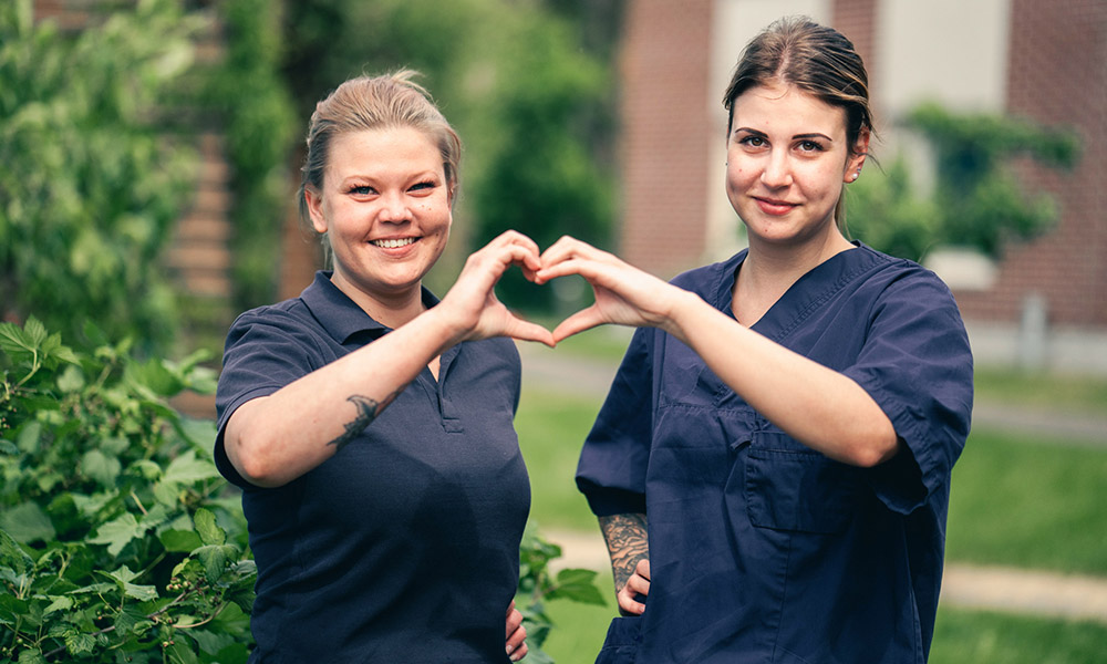 Två medarbetare på Attendo som gör ett gemensamt handhjärta